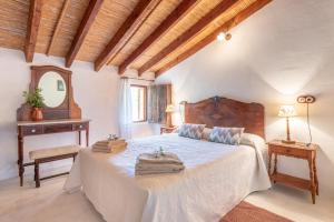 a bedroom with a large bed with a wooden headboard at Villa Cami de la Mar in Port de Soller +17 photos