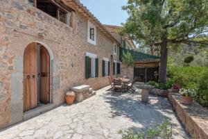 an external view of a stone house with a patio at Villa Cami de la Mar in Port de Soller