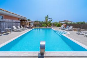 a large swimming pool with chairs at Villa Luana con piscina in Noto