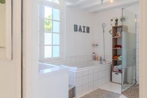 a bathroom with a bath tub and a window at Villa au bord de la Charente in Jarnac