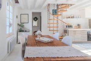 a kitchen and dining room with a wooden table and chairs at Villa au bord de la Charente in Jarnac