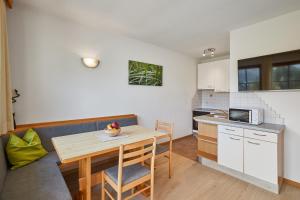 a kitchen with a wooden table and a table and chairs at Ratschingser Kreuz Blasighof in Racines