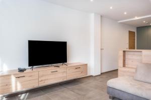 a flat screen tv on a wooden dresser in a living room at Residence Diana Apartment 402 in Terento