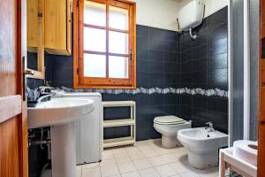 a bathroom with a sink and a toilet and a window at Villa Costa Paradiso del Sud in Costa Rei +24 photos