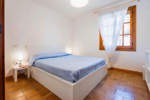 a white bedroom with a bed and a window at Villa Costa Paradiso del Sud in Costa Rei
