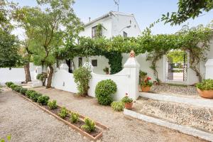 a white house with a white fence and plants at Cortijo Caracate in Archidona