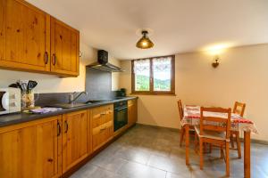 a kitchen with wooden cabinets and a table and a table and chairs at Chalet La Sportive in Cornimont