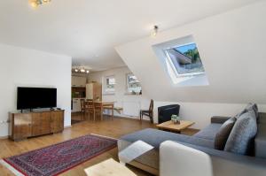 a living room with a couch and a tv at Albpartments in Meßstetten
