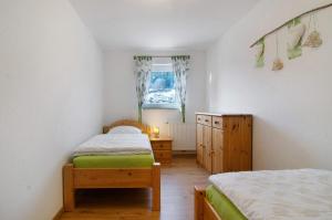 a bedroom with two twin beds and a window at Albpartments in Meßstetten