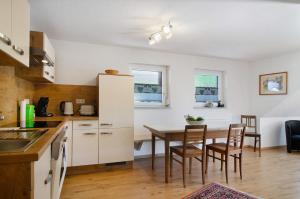 a kitchen and dining room with a table and chairs at Albpartments in Meßstetten
