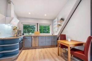 a kitchen with blue cabinets and a wooden table at Zum Kanal in Steinau