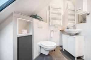 a white bathroom with a toilet and a sink at Zum Kanal in Steinau +19 photos
