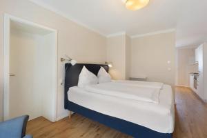 a bedroom with a white bed with a black headboard at Torhaus Schloss Wocklum in Balve
