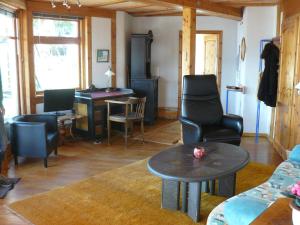 a living room with a table and chairs and a desk at Ferienwohnung Naturhaus, 50qm in Allensbach