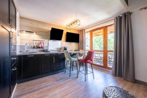 a kitchen with a table and chairs in a room at Appartement C21 in Valloire