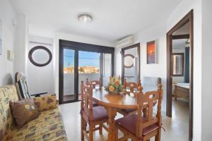 a dining room with a table and a couch at Sol y mar in Sanlúcar de Barrameda