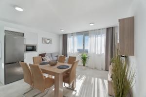 a dining room and living room with a table and chairs at Apartamento Iris Tropical in Araya