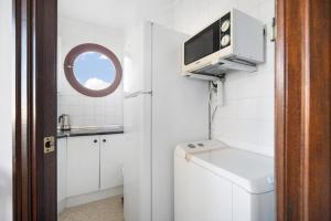 a small white bathroom with a sink and a window at Sol y mar in Sanlúcar de Barrameda +21 photos