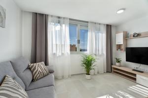 a living room with a couch and a television at Apartamento Iris Tropical in Araya