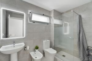 a white bathroom with a sink and a toilet at Apartamento Iris Tropical in Araya