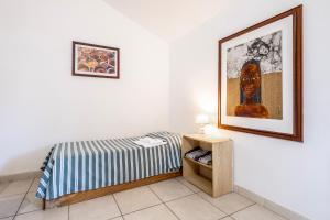 a bedroom with a bed and a picture on the wall at La Capannuccia C in Ansedónia