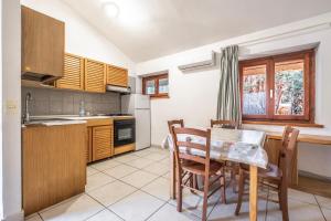 a kitchen with a table and chairs in a room at La Capannuccia C in Ansedónia