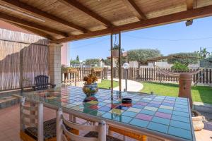 a glass table with a vase on a patio at Villa Luana con piscina in Noto