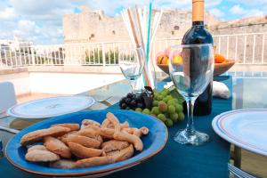 a table with a plate of food and a bottle of wine at Casa Sveva a Otranto vista mare in Otranto