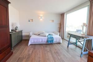 a bedroom with a bed and a desk and a window at Casa Sveva a Otranto vista mare in Otranto