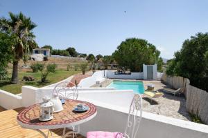 a patio with a table and chairs next to a pool at Casa De Los Pintores Facinas in Facinas