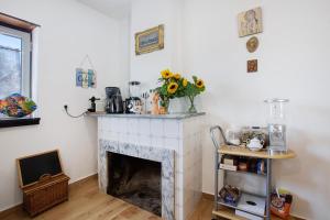 a living room with a fireplace with a vase of sunflowers at Refúgio de Fátima in Fátima