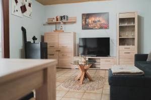 a living room with a couch and a tv at Ferienwohnungen Bullau - 2 in Erbach