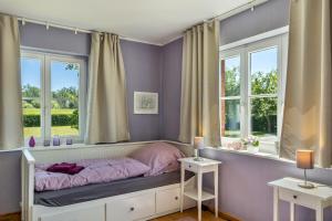 a bedroom with purple walls and a bed with windows at Der Flusshof, Scheunenwohnung in Werben