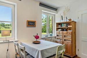 a dining room with a table and chairs and windows at Der Flusshof, Scheunenwohnung in Werben