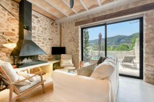 a living room with white furniture and a large window at Ca la Pasita 28 in Beniali