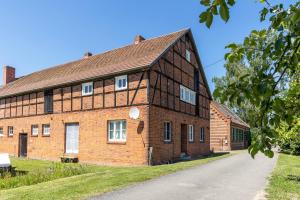 an old brick building with a road in front of it at Der Flusshof, Scheunenwohnung in Werben