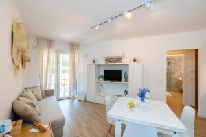 a living room with a white table and a couch at Isabel Beach and Bike in Finale Ligure