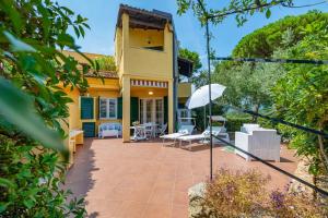 a house with a patio with chairs and an umbrella at Isabel Beach and Bike in Finale Ligure