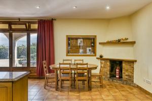 a dining room with a table and a fireplace at Les Cabretes Vilanova de la Muga in Vilanova de la Muga