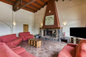 a living room with red furniture and a fireplace at Les Cabretes Vilanova de la Muga in Vilanova de la Muga
