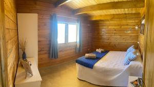 a bedroom with a bed in a wooden cabin at Miralvalle in El Gastor +7 photos