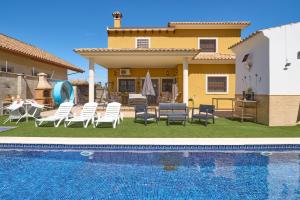 a villa with a swimming pool in front of a house at Marisol' House in Puente Genil
