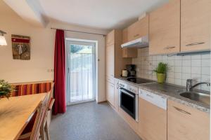 a kitchen with wooden cabinets and a counter top at Ferienwohnung Valentina in Schwendau