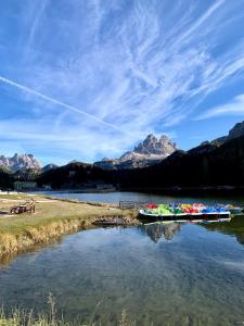 a boat on a river with mountains in the background at Alla Vecchia Dogana in Misurina