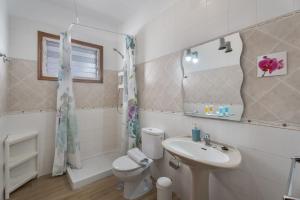 a bathroom with a sink and a toilet and a mirror at Casa Palmar La Gomera in Valle Gran Rey +28 photos