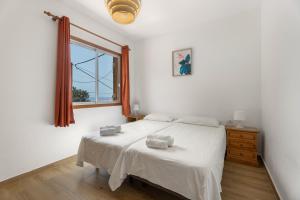 a bedroom with a white bed and a window at Casa Palmar La Gomera in Valle Gran Rey