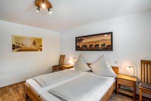 a bedroom with a bed with white sheets and two tables at Ferienwohnung Graf in Lauf