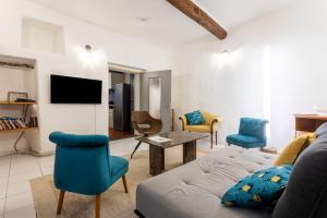 a living room with a couch and chairs and a tv at Maison Collo in Collobrières