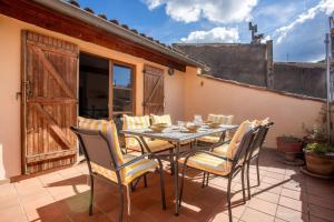 a patio with a table and chairs on a patio at Maison Collo in Collobrières