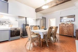 a dining room with a table and chairs in a kitchen at Maison Collo in Collobrières
